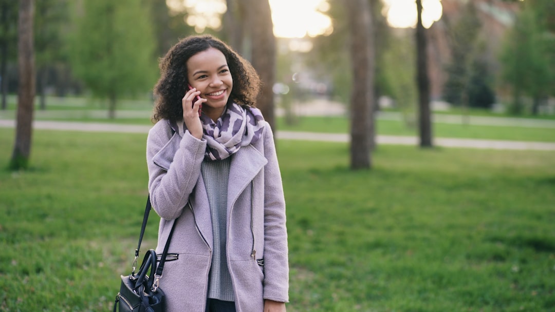 Confident woman walking with shopping bags talking on phone