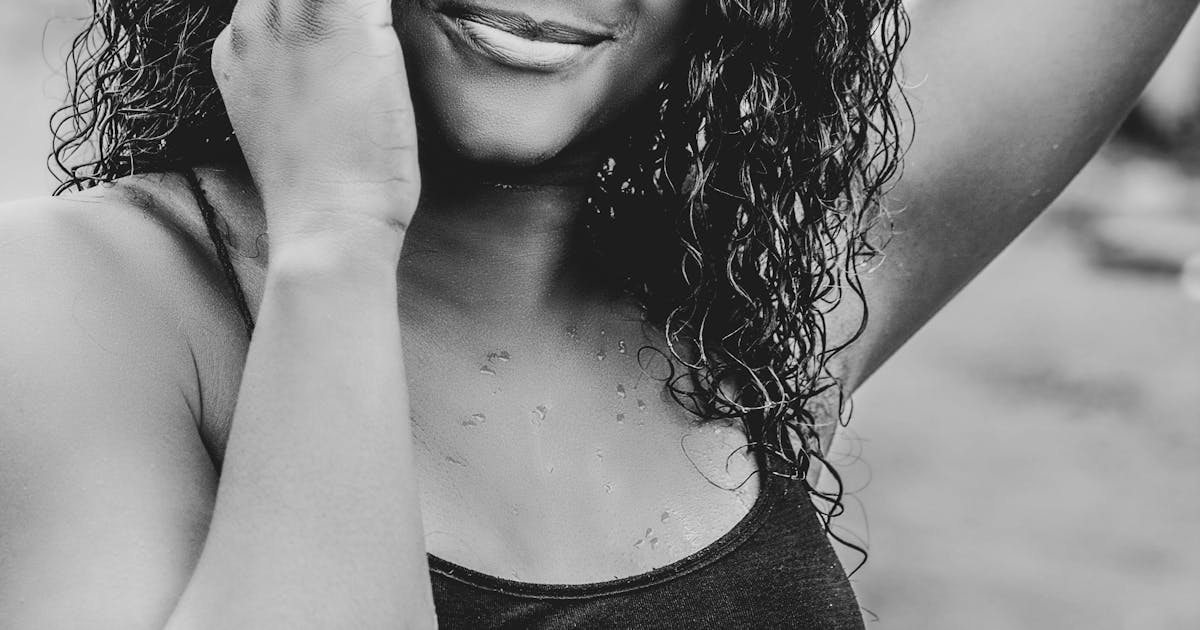 Confident woman smiling while using smartphone