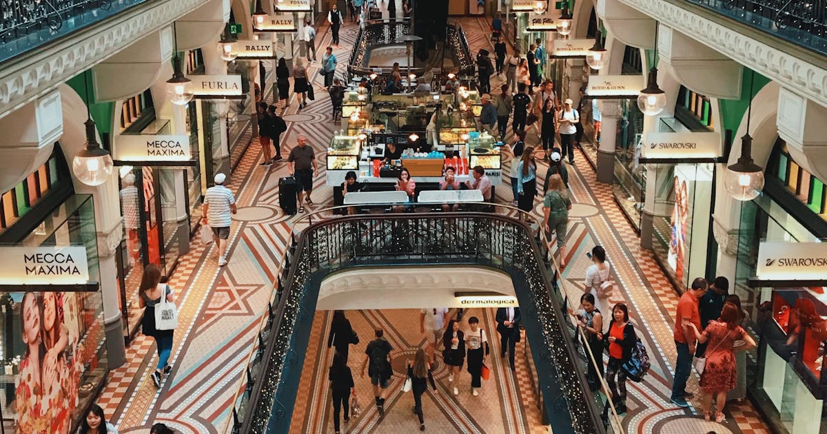 People walking inside a busy shopping mall with stores and displays