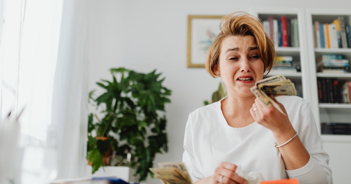 Woman counting money and looking at bills with concern