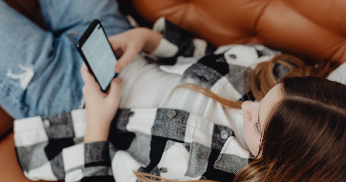 Young person scrolling through social media on phone